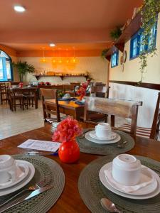 a wooden table with plates and dishes on top of it at Pousada Tranquilandia Village in Canoa Quebrada