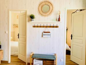 a room with a mirror on a wall with a bench at Gîte Clair de Lune in Monts-sur-Guesnes