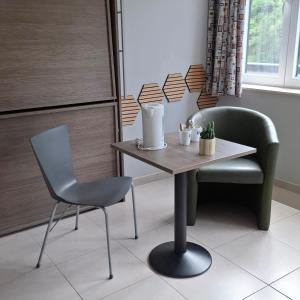 a table and a chair in a room at J-Club De Knapzak / La Besace in Bohan