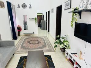 a living room with a couch and a tv at Sawaddi Homestay in Bukit Payong