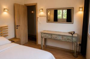 a bedroom with a bed and a mirror on the wall at Pinecone Luxury Glamping in Louvaras
