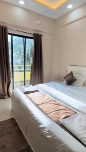 a large bed in a room with a window at Sorrento Homes in Pune