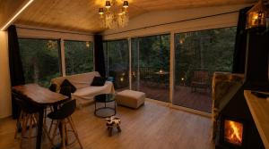 a room with a living room with a fireplace and a living room with a fire at Pinecone Luxury Glamping in Louvaras