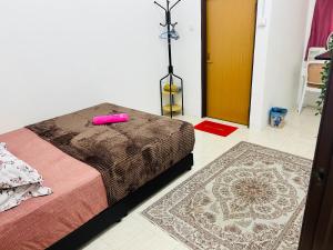 a bedroom with a bed with a pink candle on it at Sawaddi Homestay in Bukit Payong +5 photos