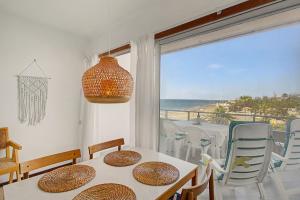 a dining room with a table and a view of the ocean at A la Playa en San Agustín in Maspalomas