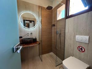 a bathroom with a sink and a shower with a mirror at Anogeio in Afitos