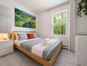 a bedroom with a bed and a window at Nature Chalet with Private Spa & Firepit in Saint-Tite-des-Caps