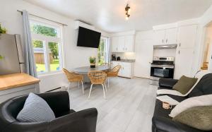 a kitchen and living room with a table and chairs at Nature Chalet with Private Spa & Firepit in Saint-Tite-des-Caps