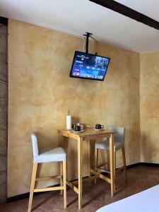 a dining room with a table and a tv on a wall at Aura LT - Vicinissima all'aeroporto in Fiumicino