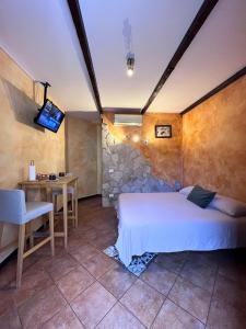 a bedroom with a bed and a table and a television at Aura LT - Vicinissima all'aeroporto in Fiumicino