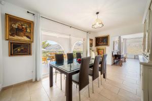 a dining room with a table and chairs at Villa Casa Blanca Carbo by Sealand Villas in Cala de Sant Vicenc