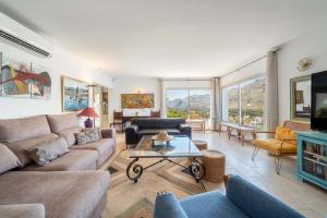 a living room with a couch and a table at Villa Casa Blanca Carbo by Sealand Villas in Cala de Sant Vicenc