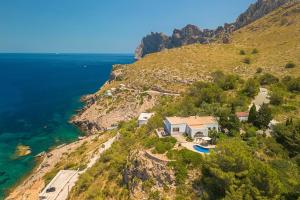 a house on a hill next to the ocean at Villa Casa Blanca Carbo by Sealand Villas in Cala de Sant Vicenc