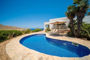 a swimming pool in front of a house at Villa Casa Blanca Carbo by Sealand Villas in Cala de Sant Vicenc