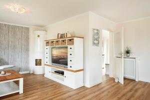 a living room with a television in a white cabinet at Alt Wrixum Haus 1 in Wrixum +21 photos