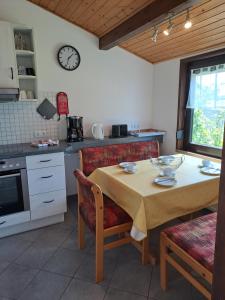 a kitchen with a table and a clock on the wall at Ferienhäuser Meiß - Feriendorf Öfingen Schwarzwald in Öfingen