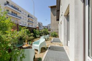 a small courtyard with white chairs and plants at Les Suites d'Orly, Évasion à 15 min de Paris in Orly
