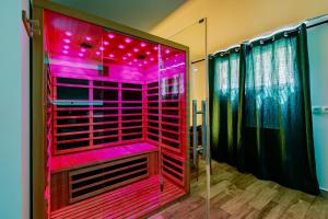 a walk in shower with pink lighting in a bathroom at Les Suites d'Orly, Évasion à 15 min de Paris in Orly +82 photos