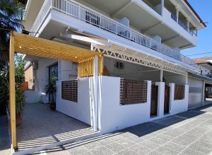 a white building with a wooden pergola at Cosy Stay in Platamonas