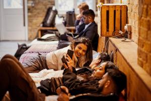 a woman looking at her cell phone in a group of people at Wombat's City Hostel London in London