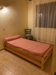 a bedroom with a bed with a chair and a window at vigne maio in Ventiseri