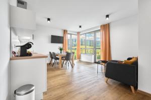 a living room with a table and chairs and a dining room at Enzian by Mountain ways in Loučná pod Klínovcem