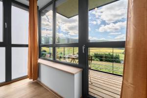 a room with a view of a balcony with windows at Enzian by Mountain ways in Loučná pod Klínovcem +15 photos