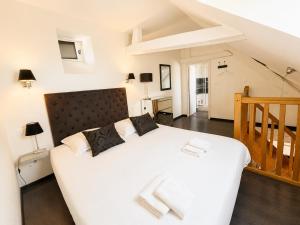 a bedroom with a large white bed and a staircase at Apt duplex ou plain pied tout confort plein centre ville Bayeux proche commerces, restaurants, avec terrasse privative ou jardin commun aménagé clos, parking gratuit à proximité, proche plages du débarquement in Bayeux