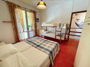 a bedroom with a bunk bed and a chair at Terraced house with garden and pool in Porto Santa Margherita di Caorle +24 photos