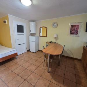 a room with a table and a bed and a kitchen at Rusałka Domki Rodzinne in Rudno
