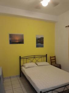 a bedroom with a bed and a yellow wall at makis in Xilosírtis