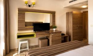 a bedroom with a bed and a desk with a television at Deluxe Suites ALL Inclusive in Sunny Beach