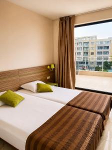 a hotel room with a bed and a large window at Deluxe Suites ALL Inclusive in Sunny Beach