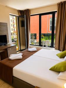 a large bed in a room with a large window at Deluxe Suites ALL Inclusive in Sunny Beach +2 photos