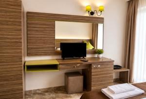 a room with a desk with a television on a wall at Deluxe Suites ALL Inclusive in Sunny Beach