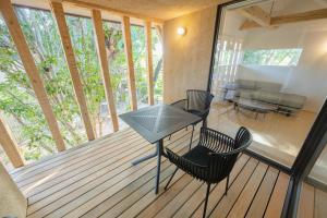 a screened in porch with a table and chairs at 椿森コムナStay in Chiba