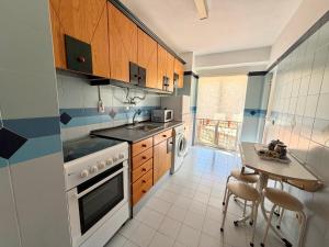 a kitchen with a sink and a table with chairs at Casa Fragata B in Armação de Pêra