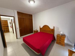 a bedroom with a red bed and a wooden cabinet at Casa Fragata B in Armação de Pêra +13 photos