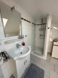 a white bathroom with a sink and a shower at Ferienwohnung Litau in Sonthofen +9 photos