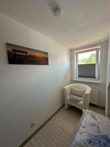 a bedroom with a bed and a chair and a window at Ferienwohnung Litau in Sonthofen