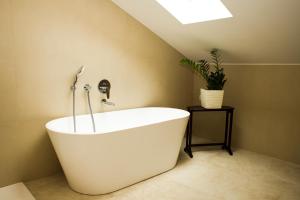 a white bath tub in a bathroom with a plant at Galathea House in Kotor +32 photos