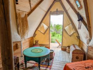 a room with a green table in a tent at Au Bonheur Nomade in Livry