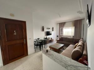 a living room with a couch and a table at Modern Flat , Master Suite , Ain Zaghouan in El Aouina Station