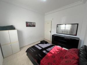 a bedroom with a bed and a flat screen tv at Modern Flat , Master Suite , Ain Zaghouan in El Aouina Station +3 photos