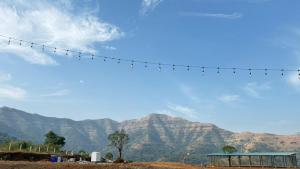 a power line with mountains in the background at Jashoda Dham Agro Tourism in Pune