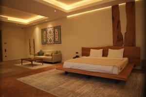 a bedroom with a large bed and a couch at August Suites & Chalets in Khŭjakent Bekati +25 photos