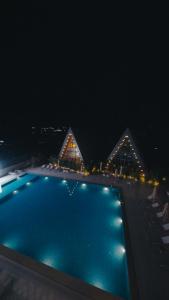 a swimming pool at night with the pyramids at August Suites & Chalets in Khŭjakent Bekati