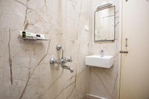 a bathroom with a sink and a mirror at Hotel Saesha International in Rāmeswaram +26 photos