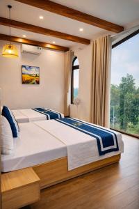a bedroom with two beds and a large window at The Windy Villa Ba Vì in Xóm Gốc Gia