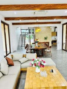 a living room with a white couch and a table at The Windy Villa Ba Vì in Xóm Gốc Gia